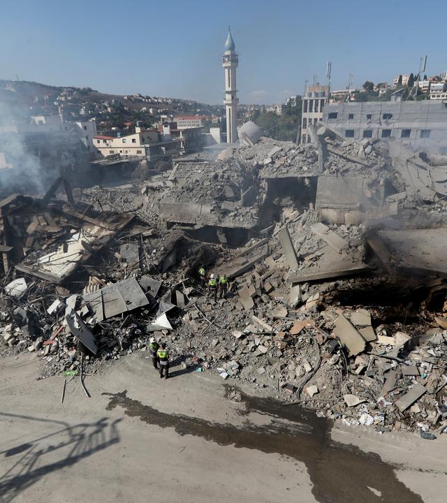 13.10.2024, Libanon, Nabatija: Rettungskräfte der Hisbollah suchen nach Opfern in den Trümmern zerstörter Gebäude in einer Geschäftsstraße, die am Samstagabend (12.10.2024) von israelischen Luftangriffen getroffen wurde.