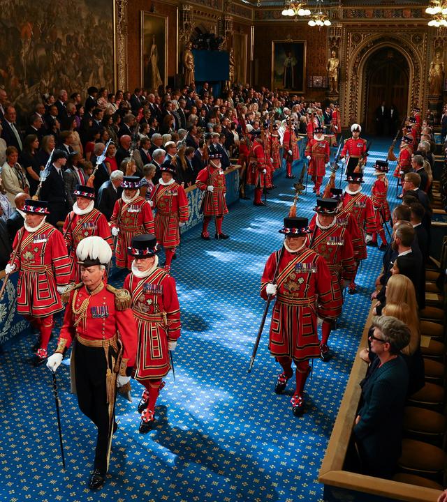 17.07.2024, Großbritannien, London: Die Leibgarde des Königs, die Yeomen of the Guard, schreiten am Tag der Parlamentseröffnung durch die Royal Gallery im House of Lords im Palace of Westminster. 