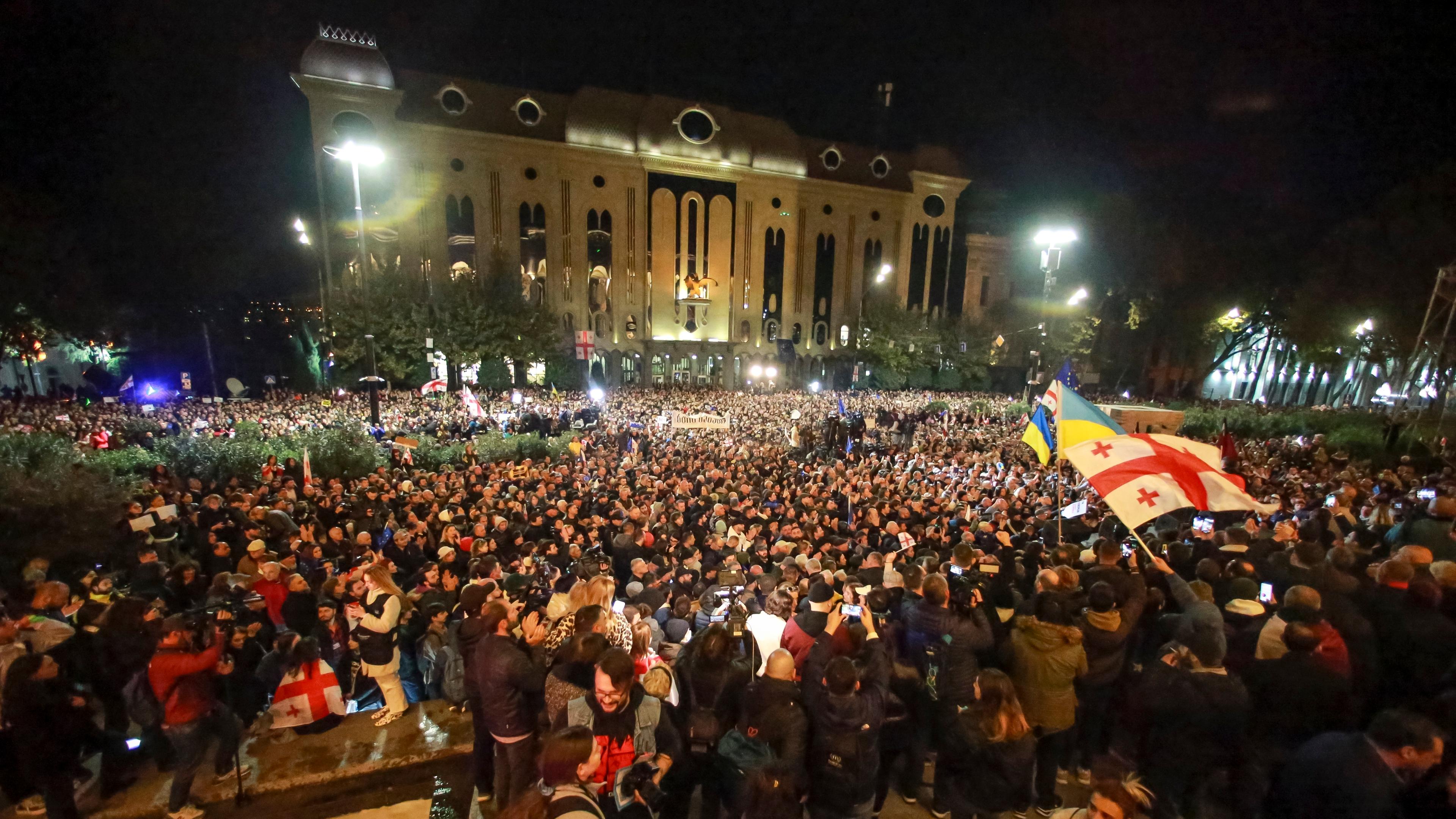 Georgien, Tiflis: Demonstranten schwenken georgische und ukrainische Nationalflaggen während einer Protestaktion der Opposition gegen die Ergebnisse der Parlamentswahle