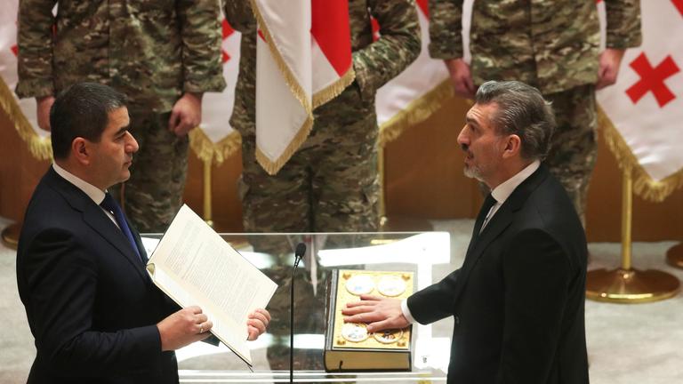 Der gewählte georgische Präsident Mikheil Kavelashvili (r) legt während seiner Vereidigungszeremonie im georgischen Parlament den Eid ab.