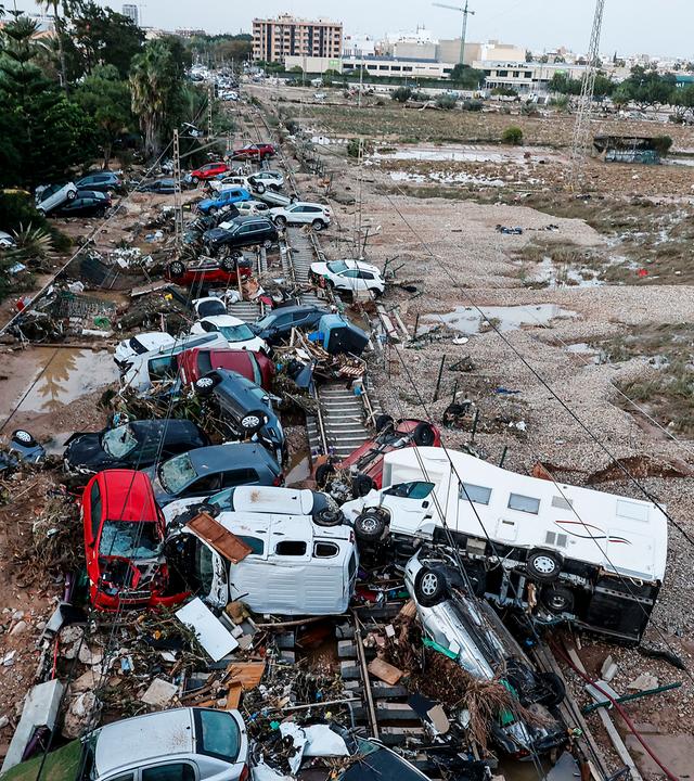 30.10.2024, Spanien, Valencia (valencianische Gemeinschaft): Autos, die durch das heftige Unwetter weggeschwemmt wurden, stehen auf den Gleisen. 