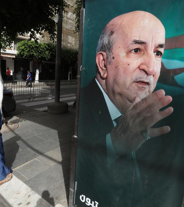 Eine Frau geht an einem Wahlbanner des amtierenden algerischen Präsidenten und des unabhängigen Präsidentschaftskandidaten Abdelmajid Tebboune vorbei, bevor die Präsidentschaftswahlen in Algier, Algerien, am 06. September 2024 stattfinden. Drei Kandidaten, darunter der algerische Präsident Abdelmajid Tebboune, treten bei den Präsidentschaftswahlen am 07. September 2024 an. 