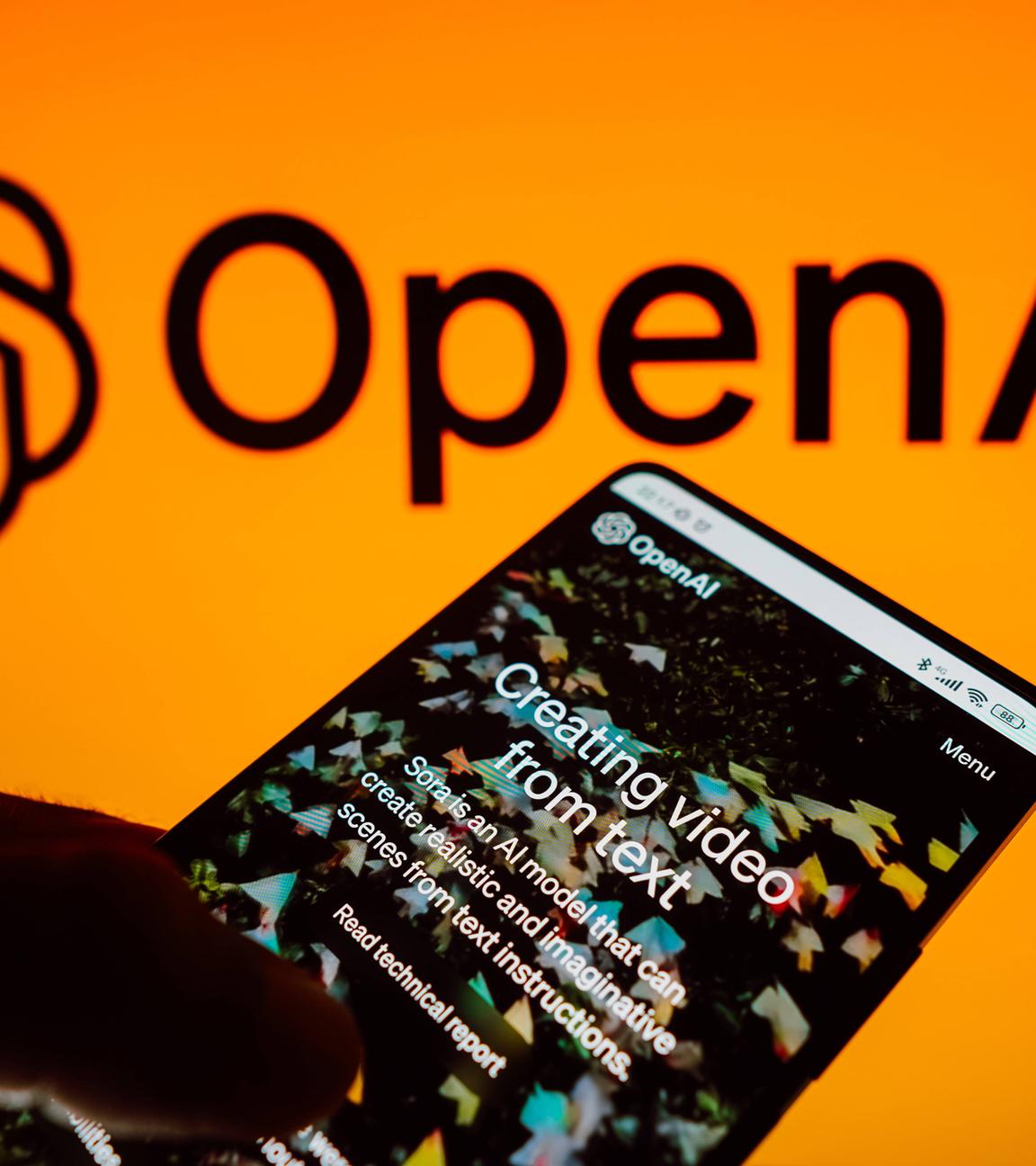 In dieser Fotoillustration wird die Startseite von Sora, der künstlichen Intelligenz für Videos von OpenAI, auf einem Smartphone-Bildschirm angezeigt, mit dem OpenAI-Logo im Hintergrund.