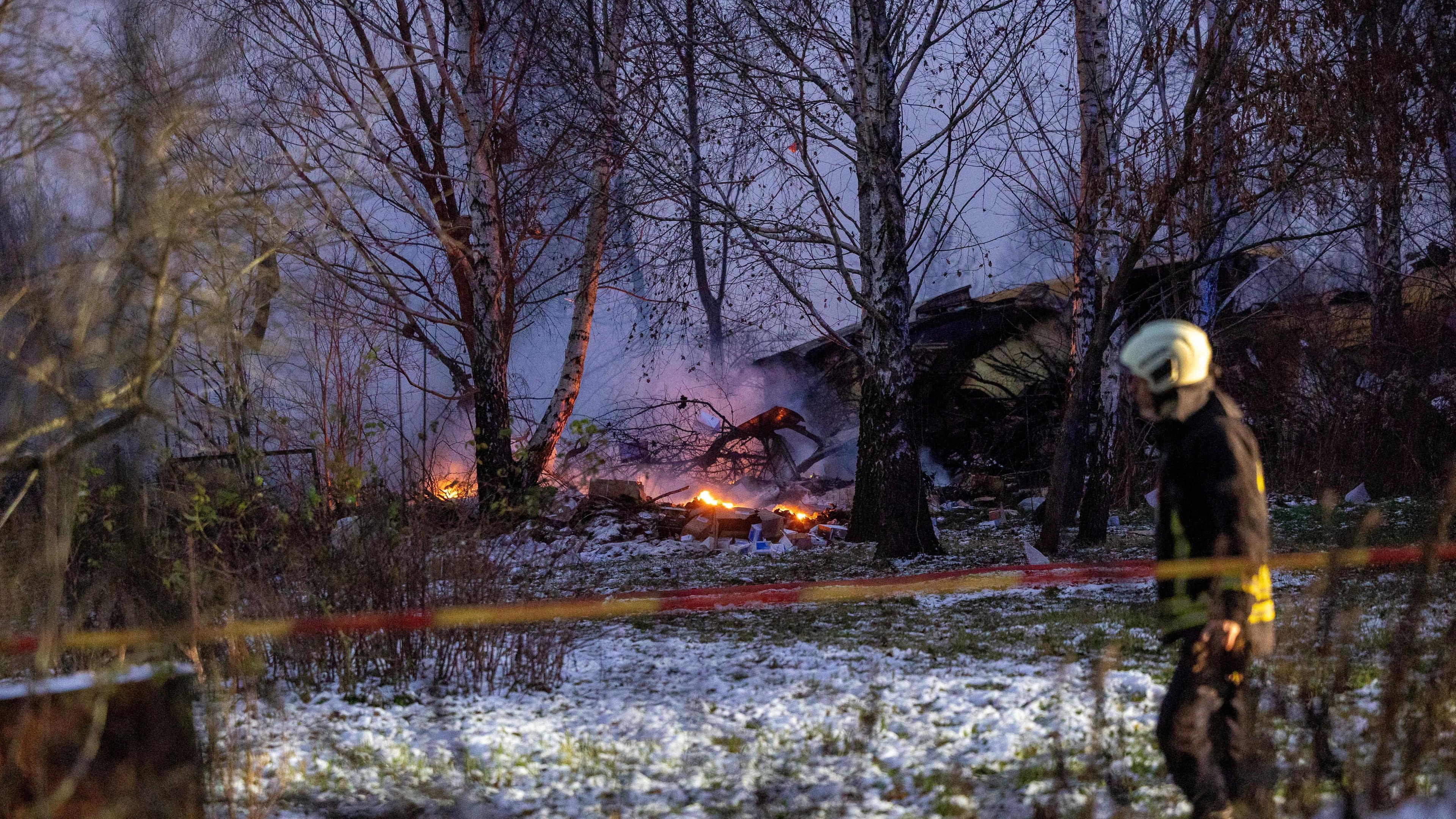 Rettungskräfte gehen an der Absturzstelle in der Nähe des internationalen Flughafens von Vilnius am Wrack der DHL-Frachtmaschine vorbei, 25.11.2024