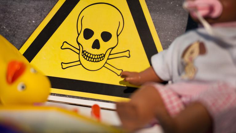 Symbol für Gift, davor Kinderspielzeug