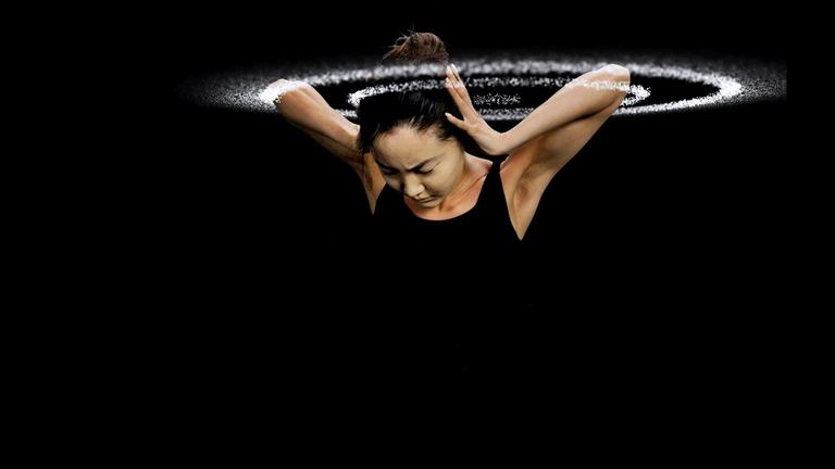 Schallwellen umkreisen den Kopf einer jungen Frau. Sie hält sich die Ohren zu.