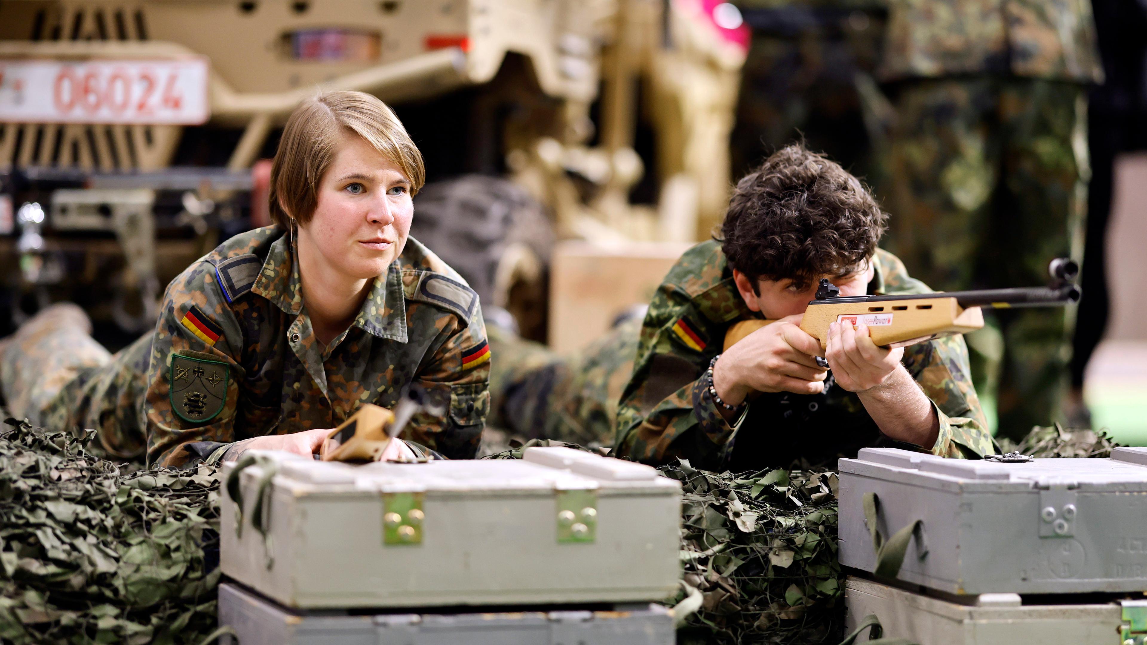 Menschen liegen mit Bundeswehr Klamotten auf dem Boden 