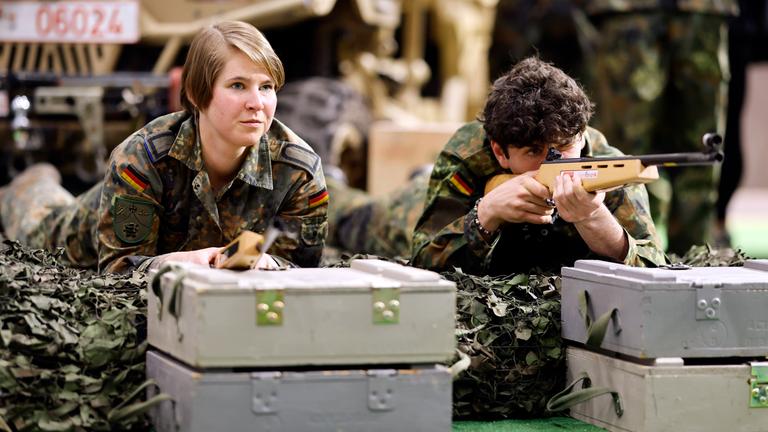 Menschen liegen mit Bundeswehr Klamotten auf dem Boden 