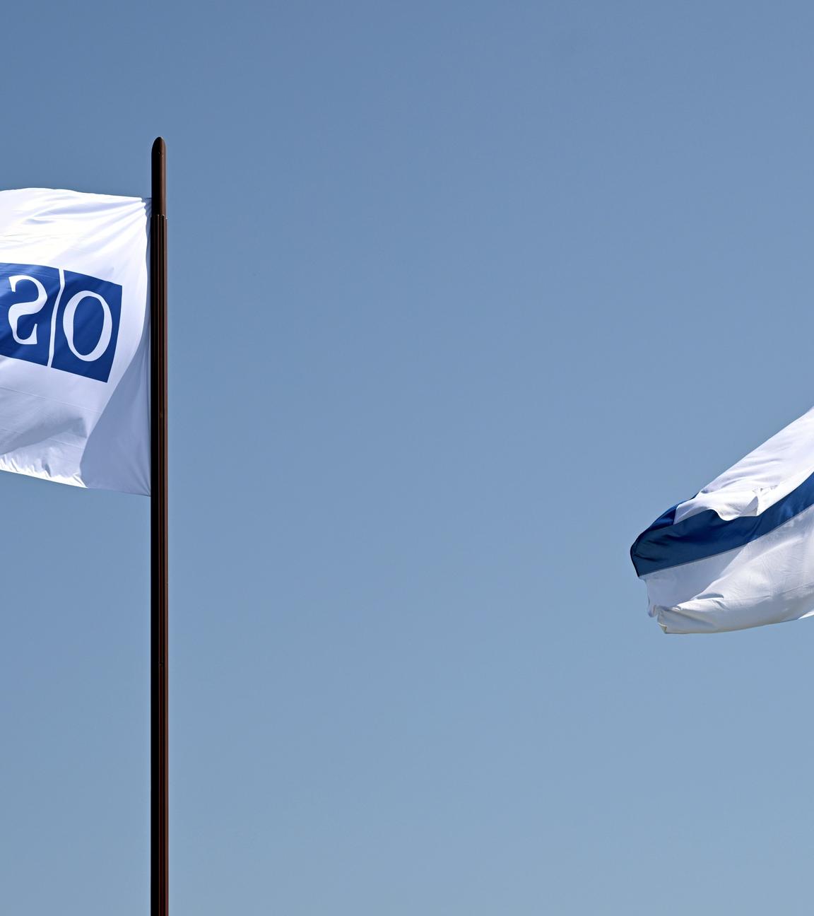 OSZE- und finnische Flaggen wehen vor der Finlandia-Halle, in der am 31. Juli 2025 die Helsinki+50-Konferenz in Helsinki, Finnland, stattfindet. Mit der Konferenz wird der 50. Jahrestag der Schlussakte von Helsinki begangen