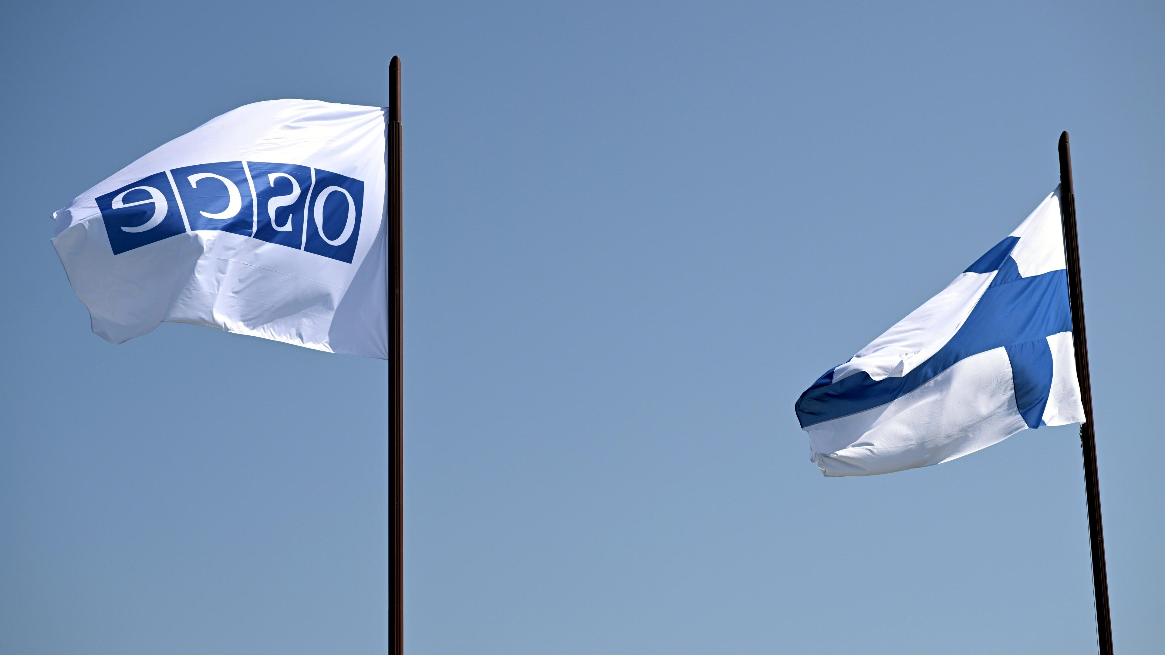 OSZE- und finnische Flaggen wehen vor der Finlandia-Halle, in der am 31. Juli 2025 die Helsinki+50-Konferenz in Helsinki, Finnland, stattfindet. Mit der Konferenz wird der 50. Jahrestag der Schlussakte von Helsinki begangen