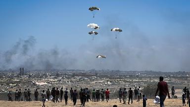 Nusairat, Gazastreifen, Palästinensisches Gebiet: Palästinenser eilen zum Ort des Geschehens, als Luftpaletten mit humanitären Hilfsgütern über Nuseirat im zentralen Gazastreifen aus einem Militärflugzeug abgeworfen werden und mit Fallschirmen herabgleiten. Dies geschieht im Rahmen einer Luftabwurfmission über dem von Israel belagerten palästinensischen Gebiet am 5. August 2025.