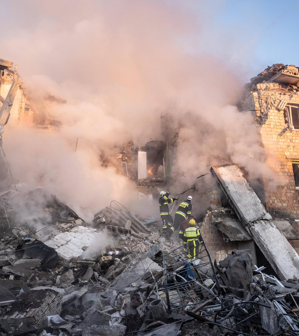 Ukrainische Rettungskräfte sind am Ort eines nächtlichen Luftangriffs auf ein Wohnhaus zu sehen.