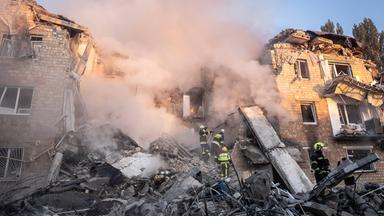 Ukrainische Rettungskräfte sind am Ort eines nächtlichen Luftangriffs auf ein Wohnhaus zu sehen.