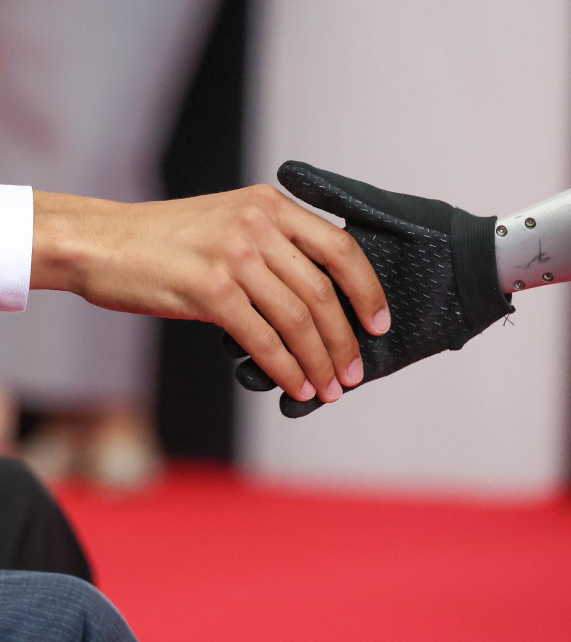 Ein mensch und ein Roboter geben sich die Hand