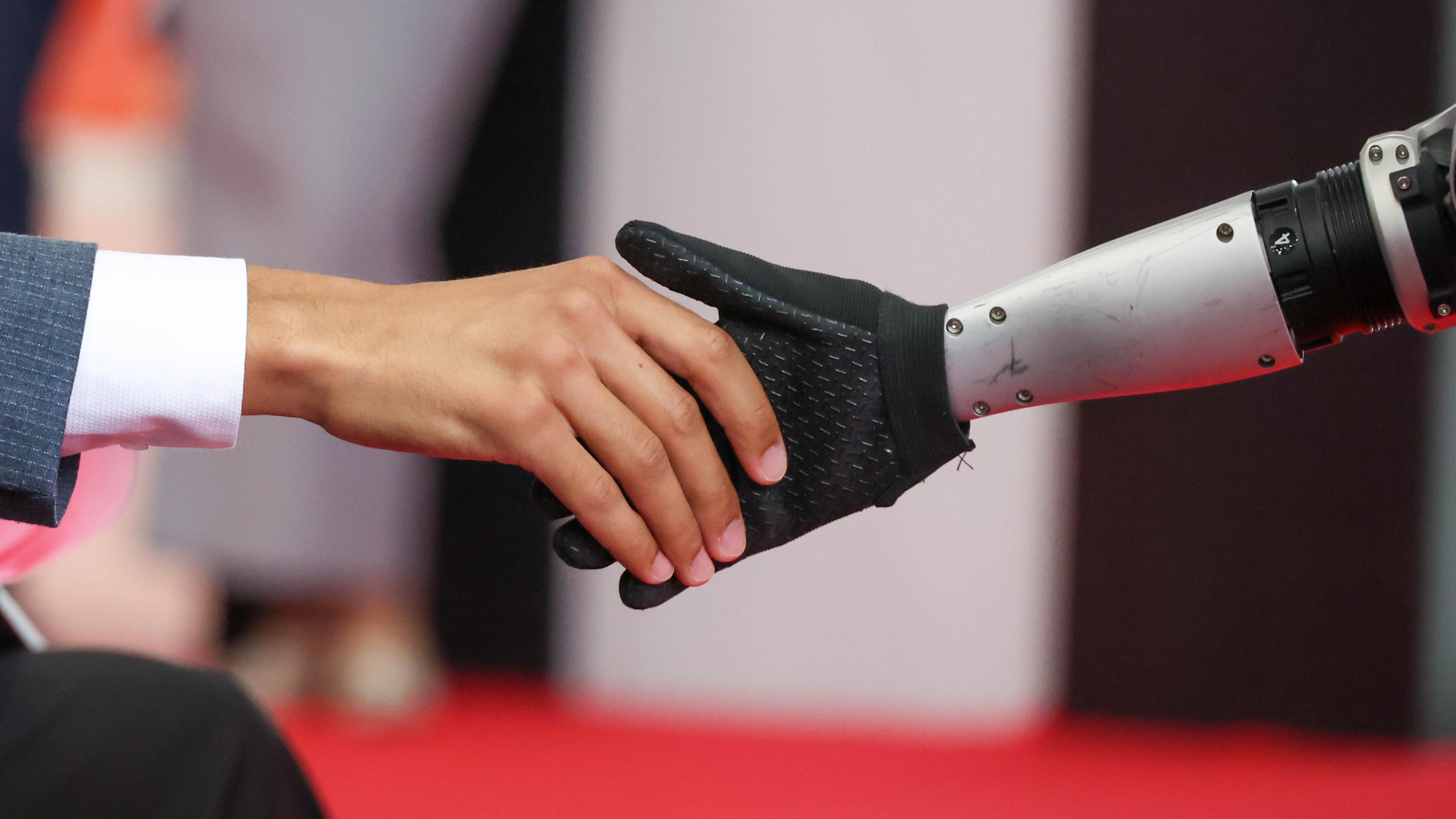 Ein mensch und ein Roboter geben sich die Hand