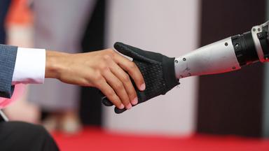Ein mensch und ein Roboter geben sich die Hand