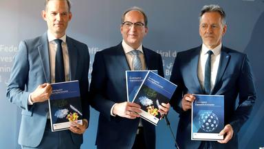 Man sieht Hendrik Streeck, Alexander Dobrindt und Holger Münch stehen nebeneinander und halten den Bericht über die Bundeslage zur Organisierte Kriminalität in den Händen. 