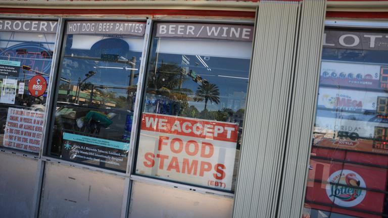 A 'We Accept Food Stamps' sign hangs in the window of a grocery store on October 31, 2025 in Miami, Florida. 