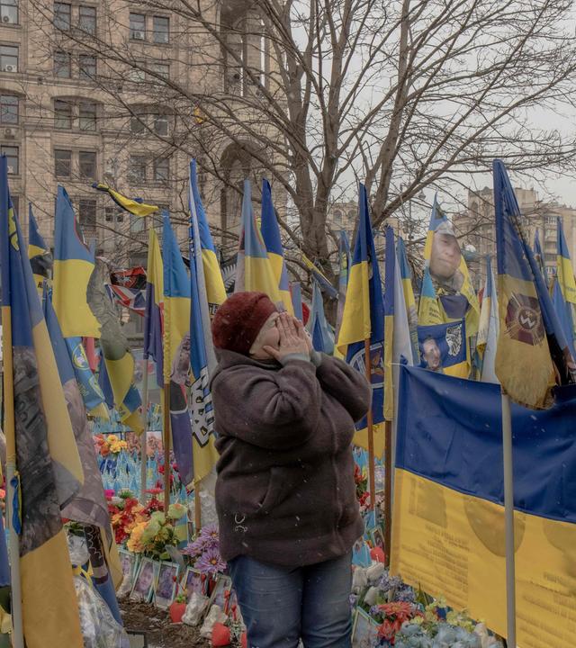 Eine Freu gedenkt ihrem Sohn  an einer behelfsmäßigen Gedenkstätte für die gefallenen ukrainischen und ausländischen Kämpfer auf dem Unabhängigkeitsplatz in Kiew