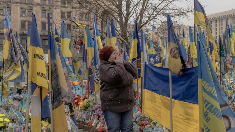 Eine Freu gedenkt ihrem Sohn  an einer behelfsmäßigen Gedenkstätte für die gefallenen ukrainischen und ausländischen Kämpfer auf dem Unabhängigkeitsplatz in Kiew