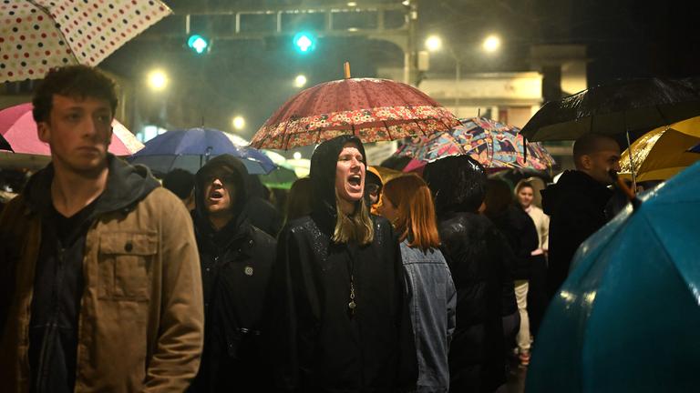 Protestors chant as they march in the rain during a protest for justice for the victims who lost their lives in the Kocani fire accident, in Skopje, on March 24, 2025.