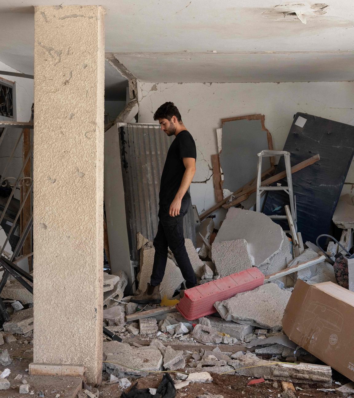 A man walks amid debris in a building hit during an Iranian missile strike in Haifa, on June 17, 2025. Israel and Iran traded deadly fire for a fifth day on June 17 in their most intense confrontation in history, fuelling fears of a drawn-out conflict that could engulf the Middle East.