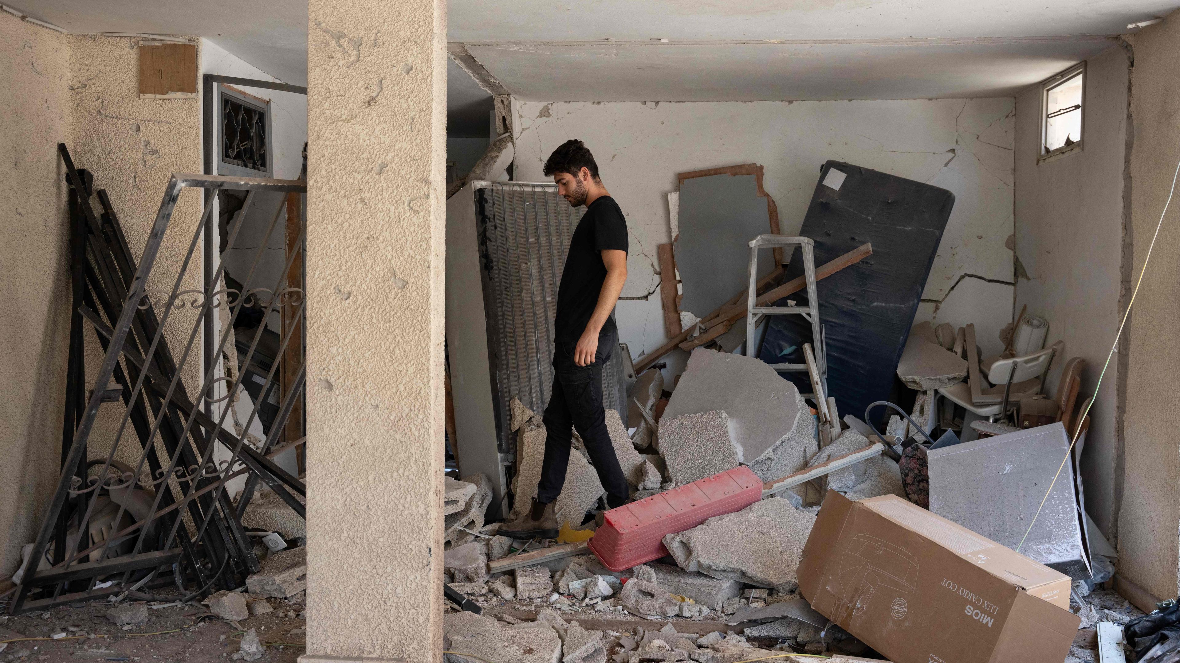 A man walks amid debris in a building hit during an Iranian missile strike in Haifa, on June 17, 2025. Israel and Iran traded deadly fire for a fifth day on June 17 in their most intense confrontation in history, fuelling fears of a drawn-out conflict that could engulf the Middle East.