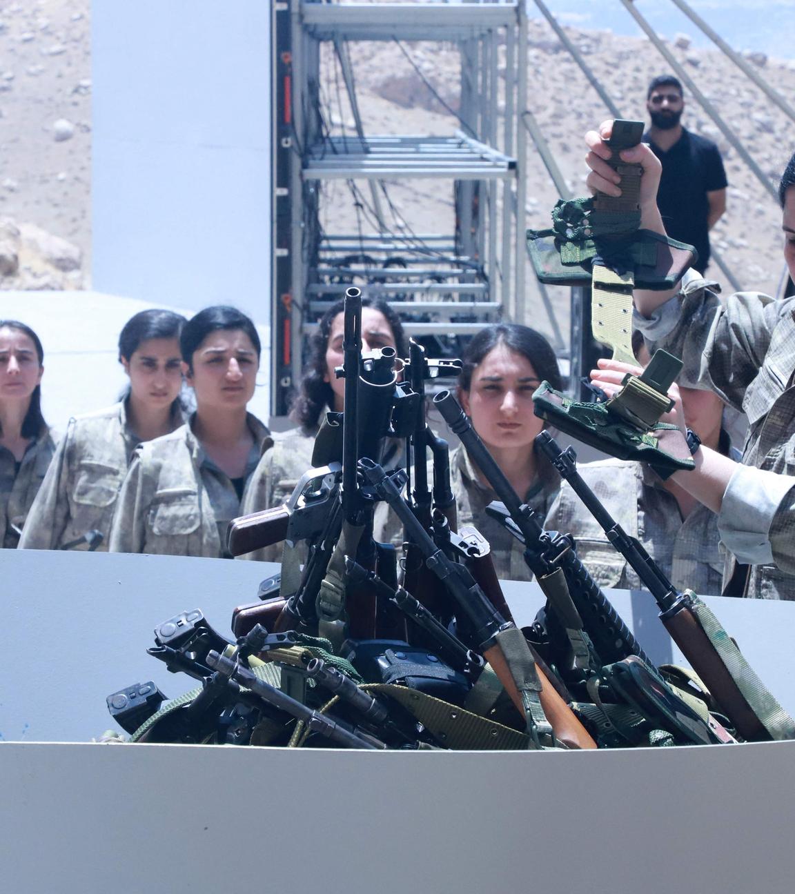 Kämpfer der Arbeiterpartei Kurdistans (PKK) stellen sich während einer Zeremonie in Sulaimaniyah in der autonomen Region Kurdistan im Irak am 11. Juli 2025 auf, um ihre Waffen in eine Grube zu legen.