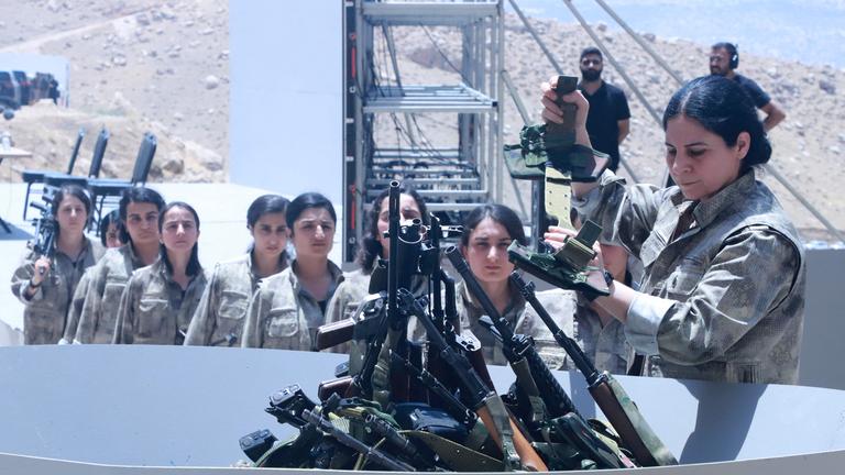 Kämpfer der Arbeiterpartei Kurdistans (PKK) stellen sich während einer Zeremonie in Sulaimaniyah in der autonomen Region Kurdistan im Irak am 11. Juli 2025 auf, um ihre Waffen in eine Grube zu legen.