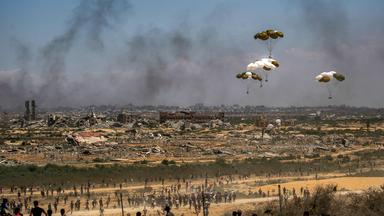 Palästinenser eilen zum Ort des Geschehens, als Hilfsgüterpaletten aus einem Militärflugzeug über Nuseirat im zentralen Gazastreifen abgeworfen werden, während einer Luftabwurfmission über dem von Israel belagerten palästinensischen Gebiet am 5. August 2025. 