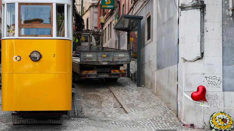 Blumen und ein Ballon mit rotem Herz (R) als Zeichen der Anteilnahme für die Opfer sind am Tag nach dem Unfall der Standseilbahn Gloria in Lissabon am 4. September 2025 zu sehen. Portugal hat am Donnerstag einen nationalen Trauertag abgehalten, nachdem eine der berühmten Standseilbahnen Lissabons entgleist war und 16 Menschen, darunter auch Ausländer, ums Leben gekommen waren. Fünf weitere Personen wurden schwer verletzt.