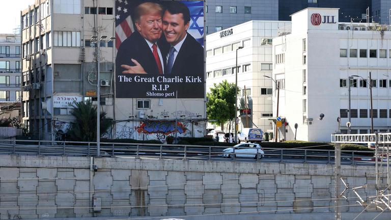 Eine Plakatwand mit einem Bild von US-Präsident Donald Trump (links), der Charlie Kirk umarmt, hängt am 13.September 2025 an der Seite eines Gebäudes in Tel Aviv