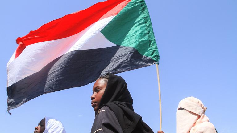 Sudanesische Schüler aus Schulen in der Region Ost-Nil der Hauptstadt halten während einer Protestkundgebung gegen die Verstöße der Rapid Support Forces (RSF) gegen die Bevölkerung von El-Fasher am 3. November 2025 in Khartum die sudanesische Flagge hoch. Nach 18 Monaten Belagerung, Bombardierung und Hunger ergriff die paramilitärische Rapid Support Forces (RSF) am 26. Oktober die Kontrolle über die Stadt El-Fasher im Westen des Sudan und verdrängte damit die letzte Bastion der Armee in der westlichen Region Darfur im Sudan. Die Staatsanwaltschaft des Internationalen Strafgerichtshofs (ICC) äußerte „tiefe Besorgnis und größte Beunruhigung” über Berichte aus El-Fasher über Massenmorde, Vergewaltigungen und andere mutmaßlich begangene Verbrechen.