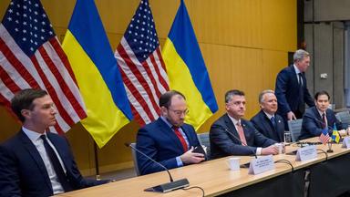 US-Außenminister Marco Rubio (5. v. l.), US-Sonderbeauftragter Steve Witkoff (4. v. l.), US-Armeeminister Daniel Driscoll (nimmt Platz) und Jared Kushner (l.), Schwiegersohn von US-Präsident Donald Trump, gegenüber der ukrainischen Delegation während der Gespräche über einen US-Plan zur Beendigung des Krieges in der Ukraine in der US-Vertretung in Genf am 23. November 2025. US-Außenminister Marco Rubio traf am Morgen des 23. November 2025 in Genf ein, um über einen US-Plan zur Beendigung des Ukraine-Krieges zu diskutieren, nachdem Washington Verhandlungsspielraum für den umstrittenen Vorschlag signalisiert hatte. Auch ukrainische, europäische und kanadische Regierungsvertreter versammelten sich in der Schweizer Stadt.