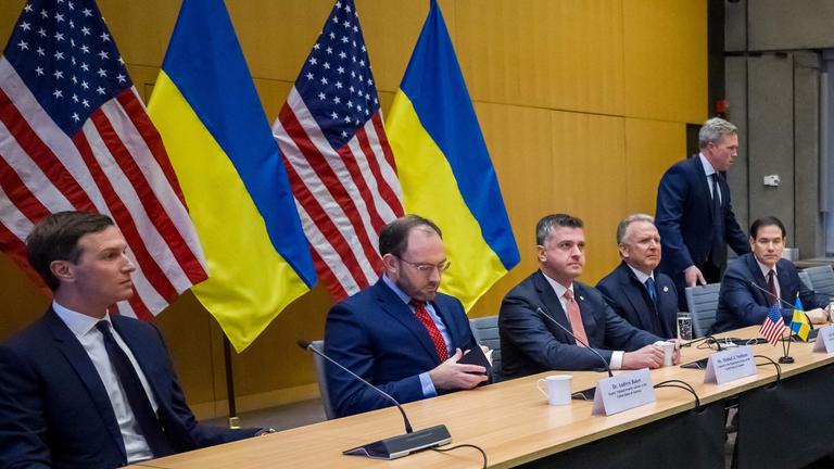 US-Außenminister Marco Rubio (5. v. l.), US-Sonderbeauftragter Steve Witkoff (4. v. l.), US-Armeeminister Daniel Driscoll (nimmt Platz) und Jared Kushner (l.), Schwiegersohn von US-Präsident Donald Trump, gegenüber der ukrainischen Delegation während der Gespräche über einen US-Plan zur Beendigung des Krieges in der Ukraine in der US-Vertretung in Genf am 23. November 2025. US-Außenminister Marco Rubio traf am Morgen des 23. November 2025 in Genf ein, um über einen US-Plan zur Beendigung des Ukraine-Krieges zu diskutieren, nachdem Washington Verhandlungsspielraum für den umstrittenen Vorschlag signalisiert hatte. Auch ukrainische, europäische und kanadische Regierungsvertreter versammelten sich in der Schweizer Stadt.