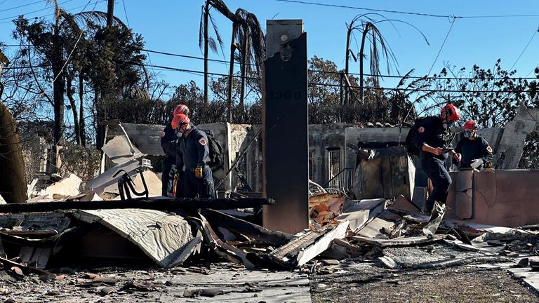 Los Angeles, Jan. 15, 2025: Feuerwehrleute arbeiten in einem durch das Palisades-Feuer zerstörten Gebiet im Stadtteil Pacific Palisades in Los Angeles
