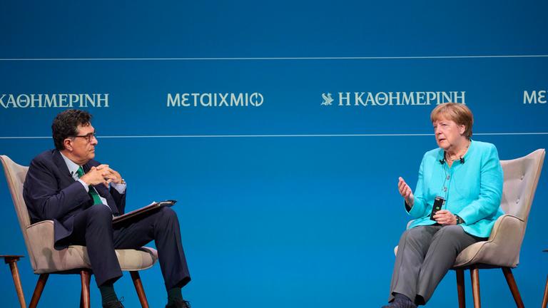 Former German Chancellor Angela Merkel, right, answers a question to Executive Editor of Kathimerini newspaper Alexis Papahelas during the presentation of her book "Freedom"