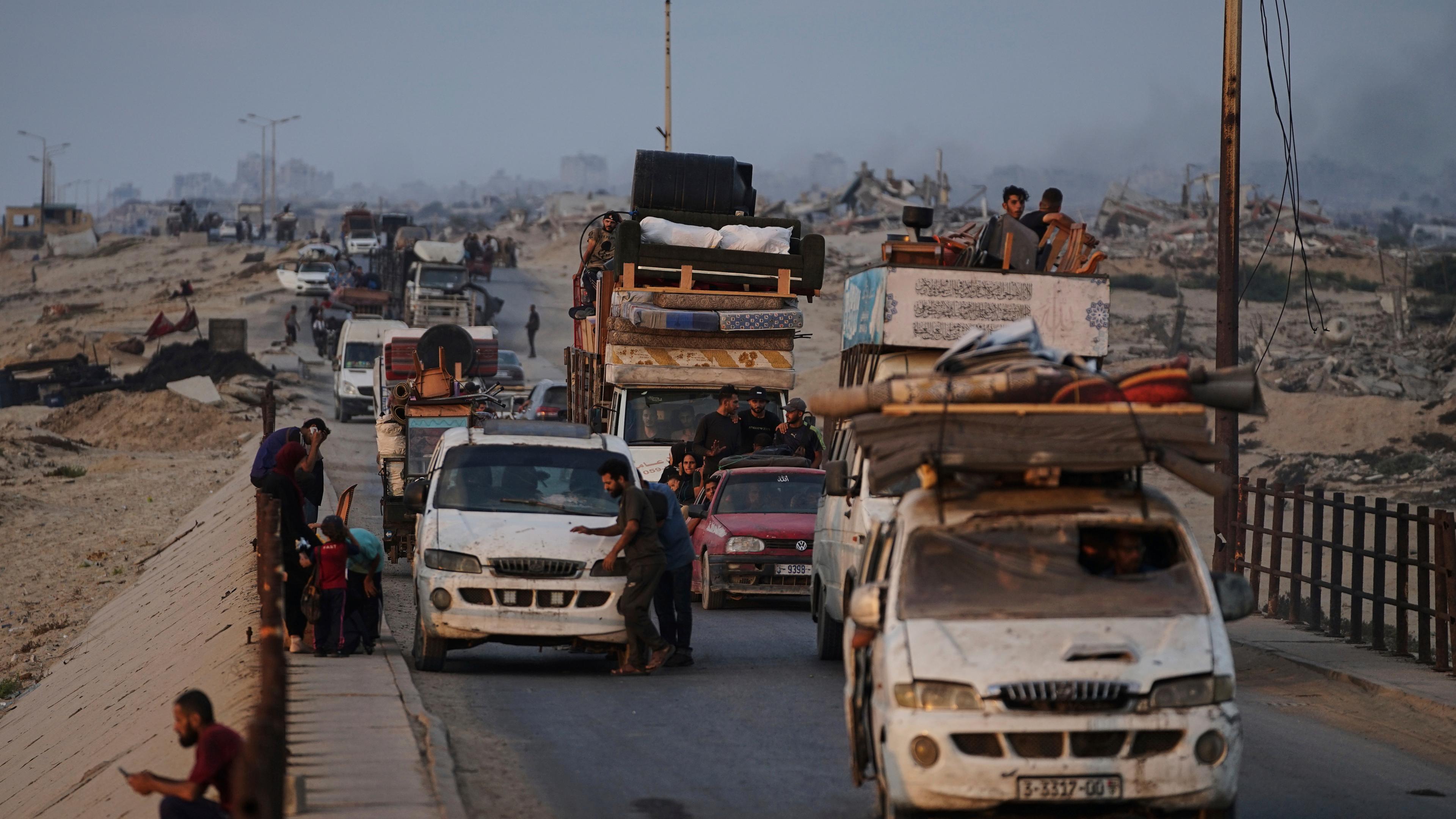 Displaced Palestinians fleeing northern Gaza carry their belongings along the coastal road toward southern Gaza, Saturday, Sept. 6, 2025.