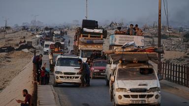 Displaced Palestinians fleeing northern Gaza carry their belongings along the coastal road toward southern Gaza, Saturday, Sept. 6, 2025.