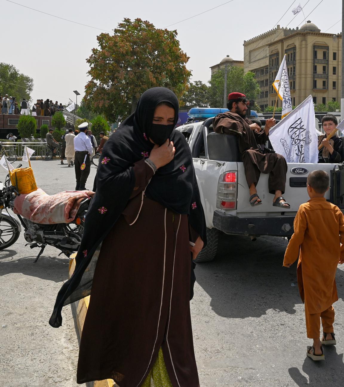 Frau läuft durch Menge von Taliban Kämpfern