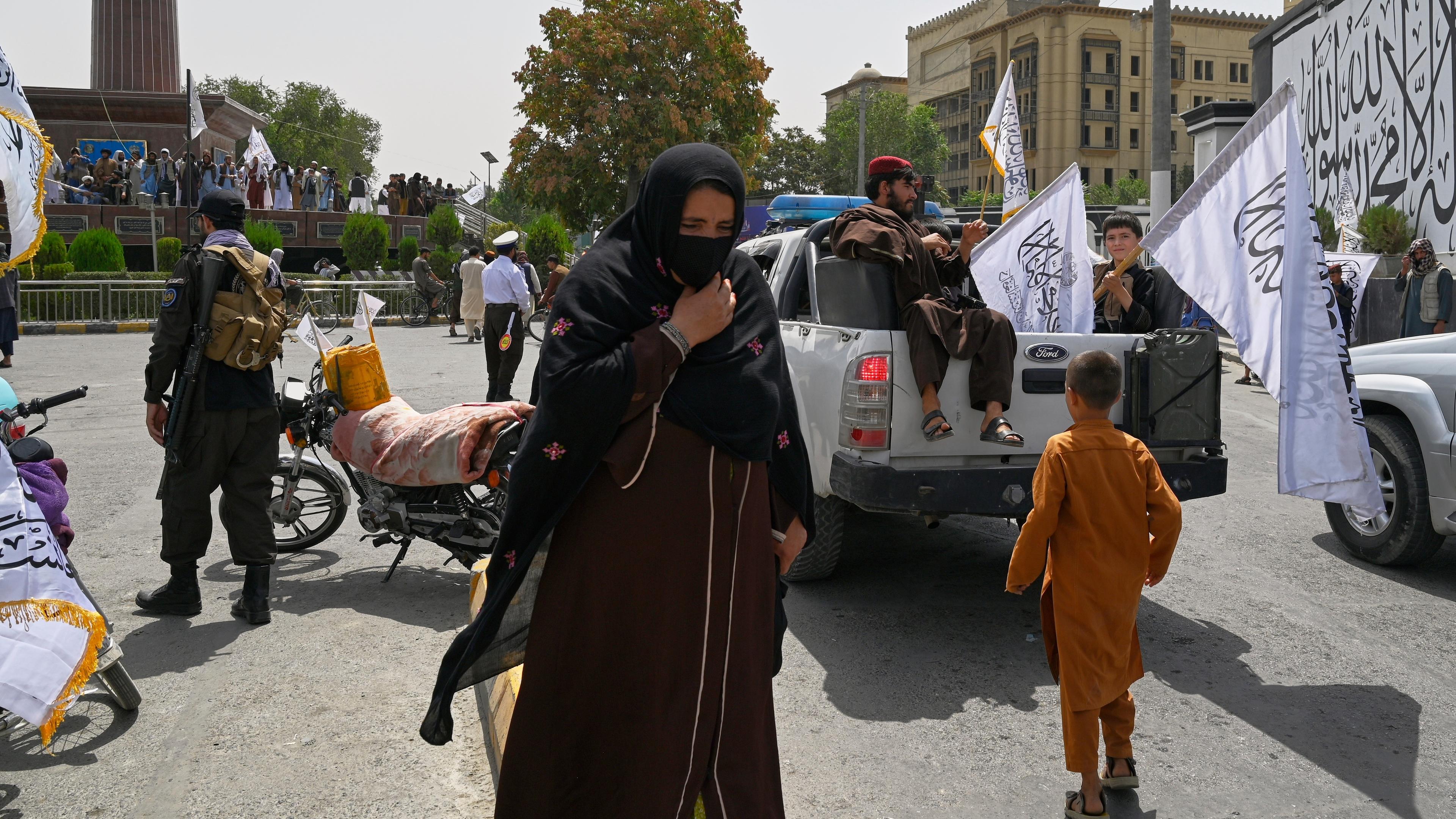Frau läuft durch Menge von Taliban Kämpfern