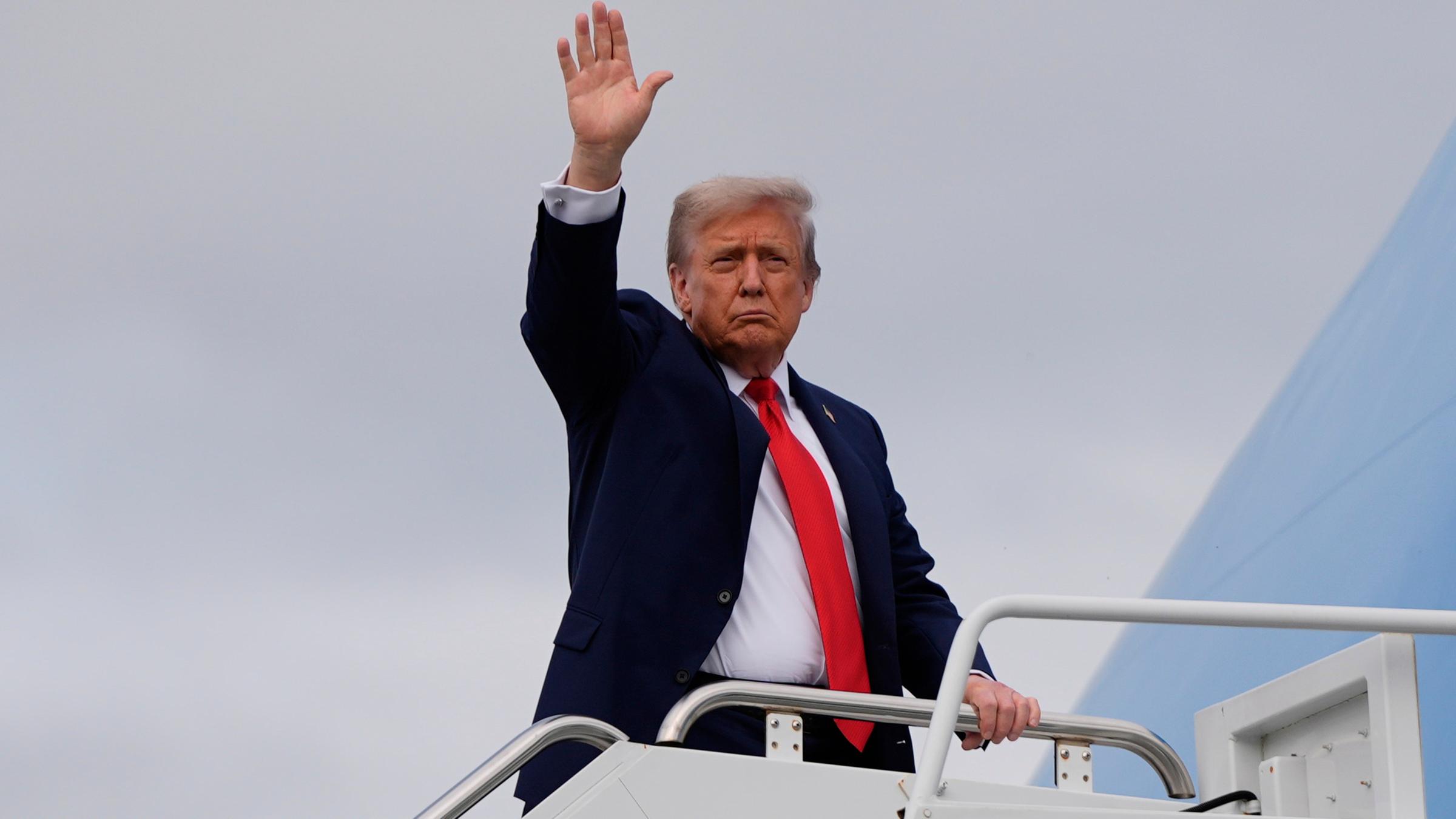 President Donald Trump waves as he boards Air Force One after meeting with Russia's President Vladimir Putin at Joint Base Elmendorf-Richardson