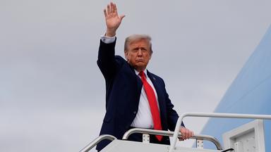 President Donald Trump waves as he boards Air Force One after meeting with Russia's President Vladimir Putin at Joint Base Elmendorf-Richardson