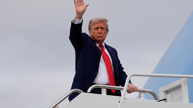 President Donald Trump waves as he boards Air Force One after meeting with Russia's President Vladimir Putin at Joint Base Elmendorf-Richardson