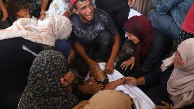 Palestinian relatives mourn over the body of a man killed in an Israeli strike, at Nasser Hospital in Khan Younis, southern Gaza Strip