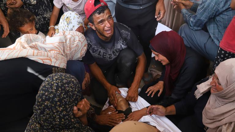 Palestinian relatives mourn over the body of a man killed in an Israeli strike, at Nasser Hospital in Khan Younis, southern Gaza Strip