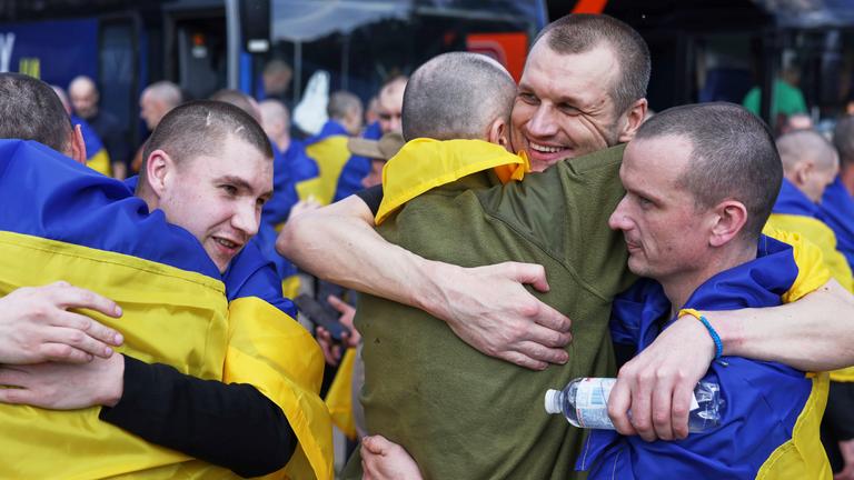 Ukrainische Soldaten umarmen sich, nachdem sie nach einem Austausch zwischen Russland und der Ukraine aus der Gefangenschaft zurückgekehrt sind, in der Region Tschernyhiv, Ukraine, Freitag, 23. Mai 2025.