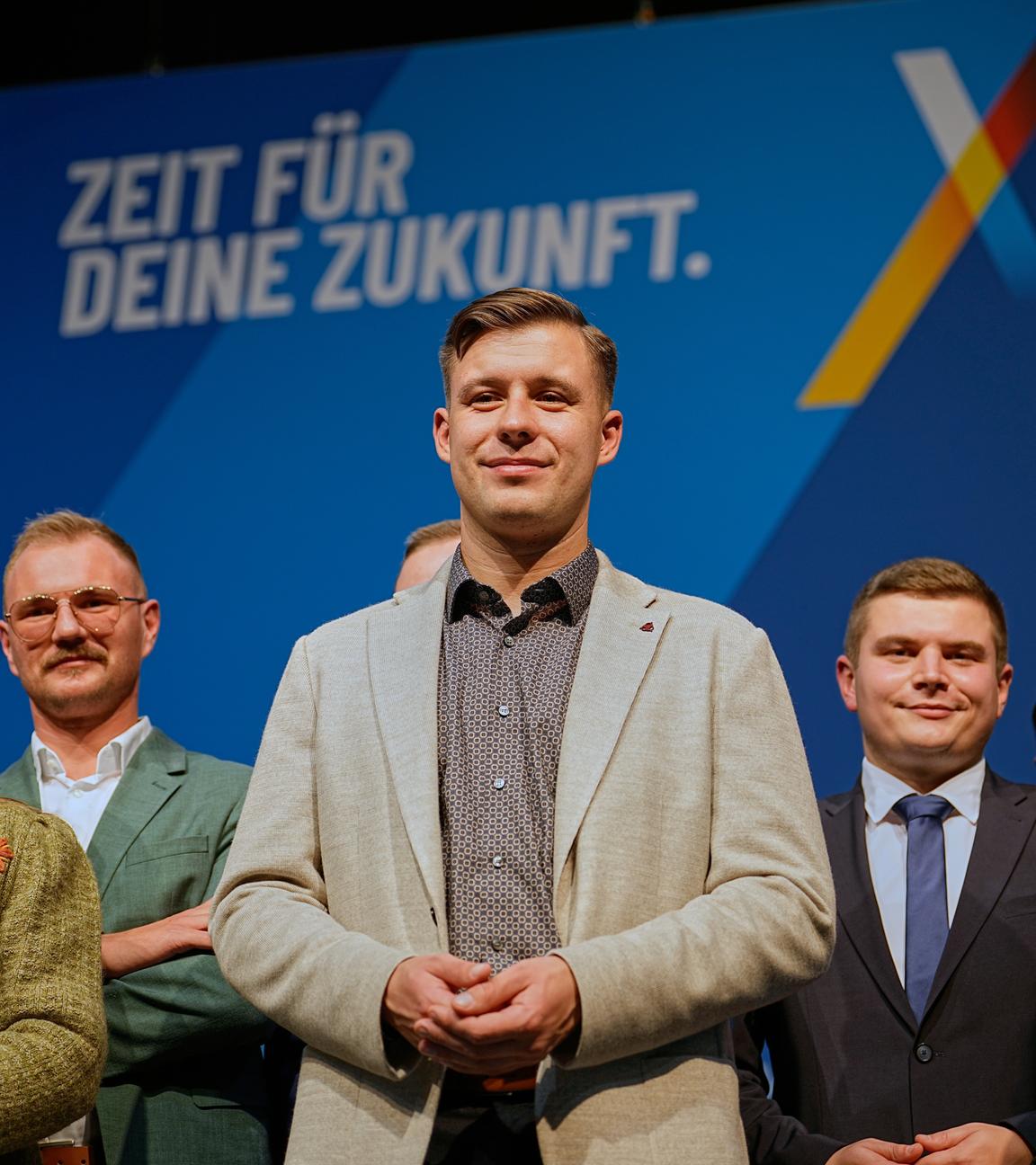 Der gewählte Vorsitzende Jean-Pascal Hohm (Mitte) steht zusammen mit anderen Vorstandsmitgliedern der AfD-Jugendpartei „Generation Deutschland“ auf dem Podium nach der Neugründung der AfD-Jugendorganisation in Gießen, Deutschland, am Samstag, 29. November 2025.
