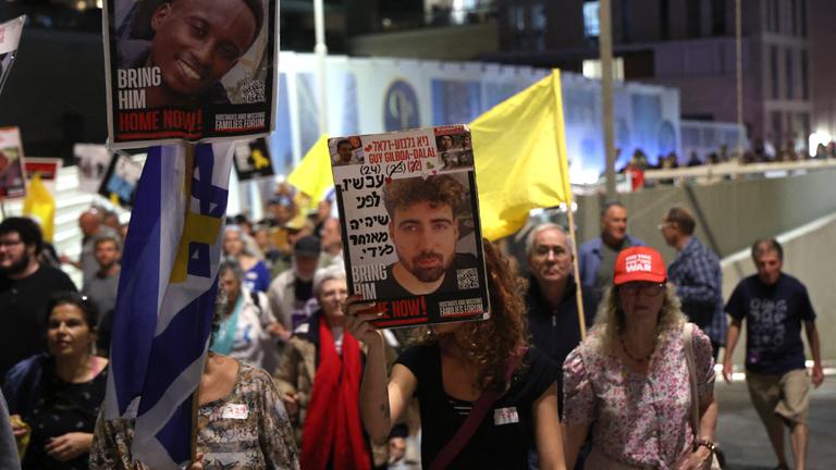 Hunderte Menschen versammeln sich am 4. Oktober 2025 in Jerusalem, um ein Ende der Angriffe auf Gaza und die Rückkehr der israelischen Geiseln zu fordern, und halten dabei Transparente hoch.