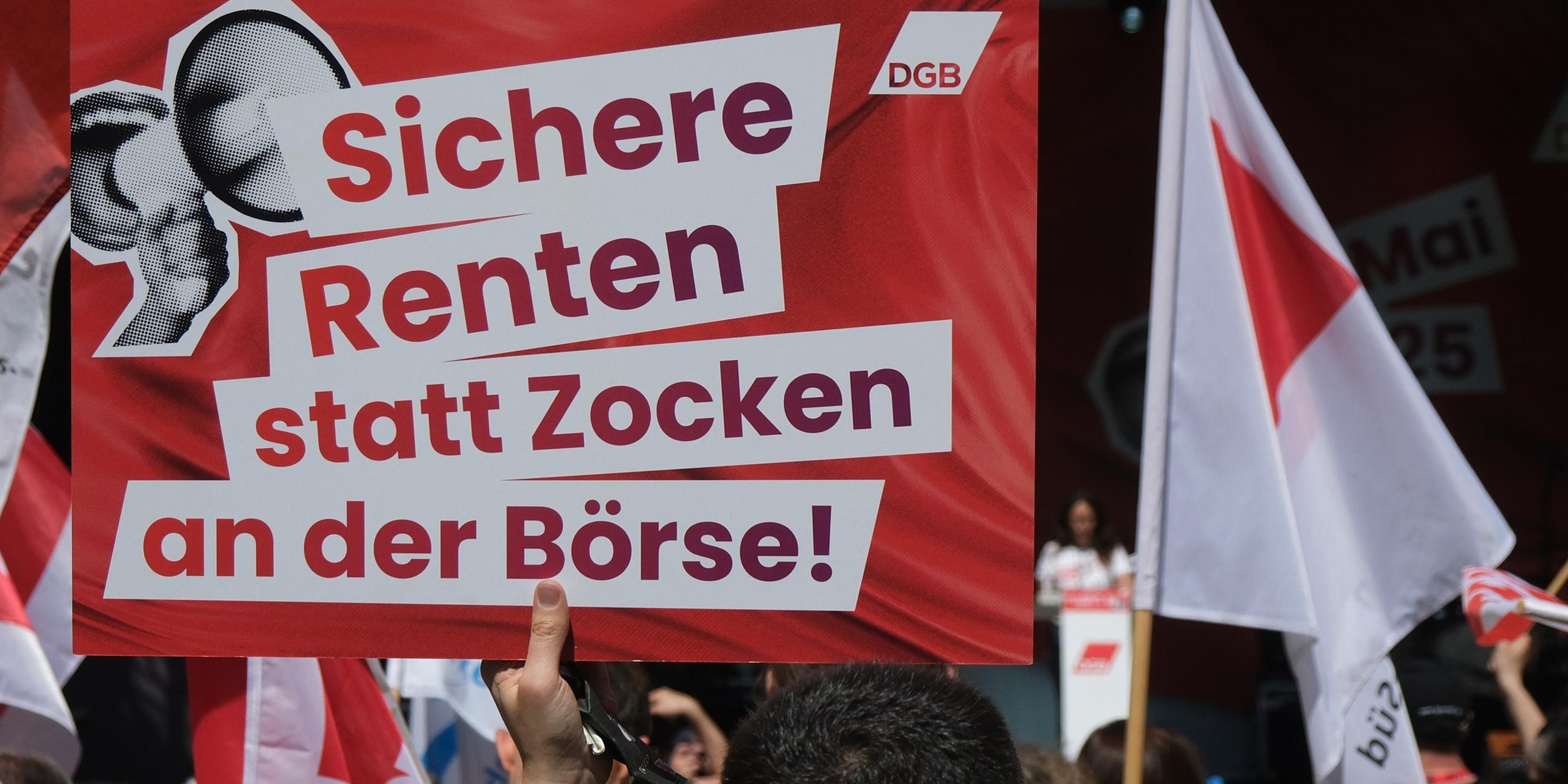 Ein Transparent mit dem Aufdruck «Sichere Renten statt Zocken an der Börse!» und Fahnen bei einer Veranstaltung des Deutschen Gewerkschaftsbundes zum 1. Mai